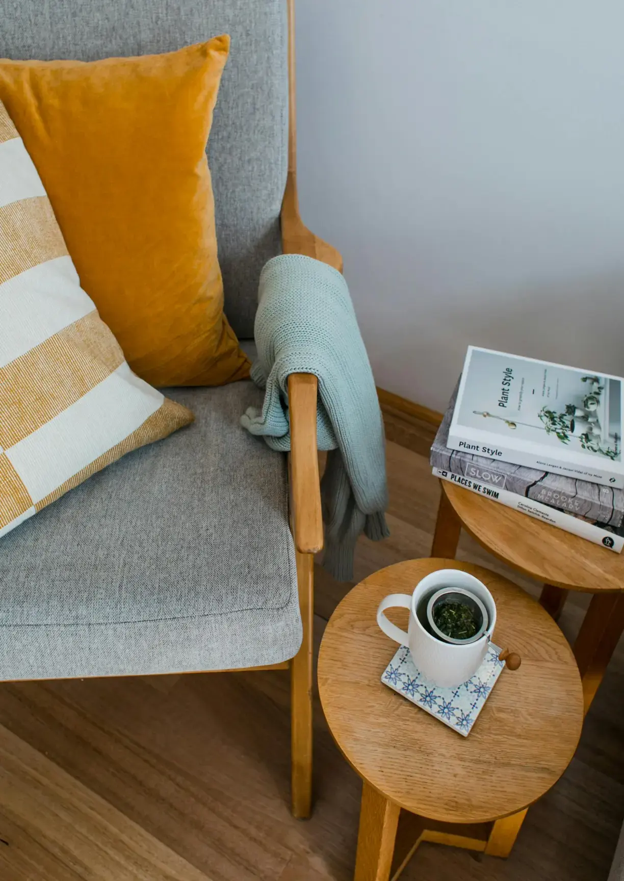 Mysig läshörna med fåtölj, dekorativa kuddar och en kopp te inför en bostadsvisning